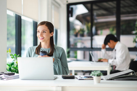 Businesswoman enjoy working with coffee at work place,relax happy. business concept.の写真素材