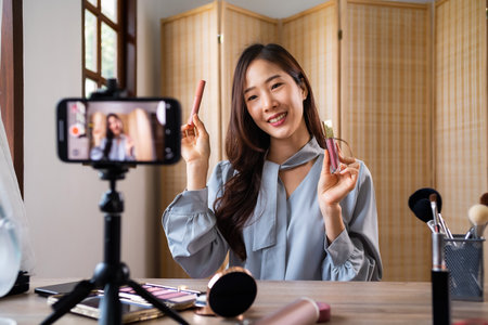 Beauty blogger, young asian woman, girl vlogger posting, showing, reviews cosmetics products while recording video, tutorial to share on social media. Business online influencer on smartphone.の写真素材