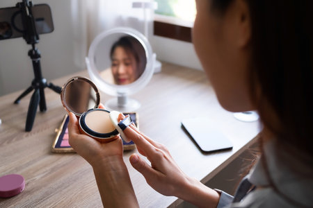 Beauty blogger, asian young woman, girl vlogger makeup face, showing, reviews cosmetics products while recording video, tutorial to share on social media. Business online influencer on smartphone.の写真素材