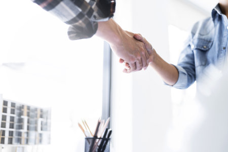 Image of engineer dealings or shaking hand for architectural project. working with laptop and engineering tools on workplace.の写真素材