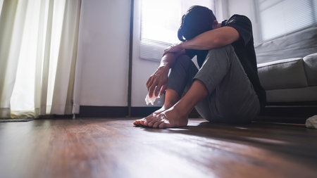 Asian man with depression sitting alone on the floor.の写真素材