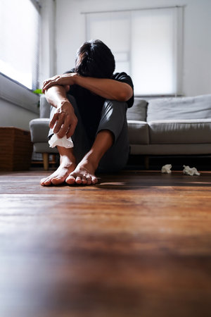 Asian man with depression sitting alone on the floor.の写真素材