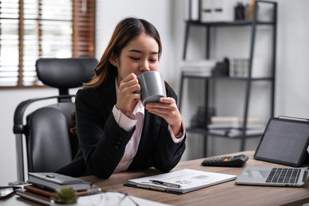 Businesswoman enjoy working with coffee at work place,relax happy. business concept.の写真素材