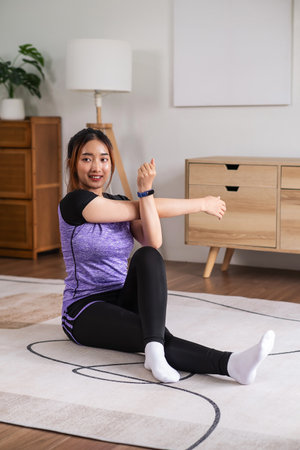 Asian woman in sports wear warm up before workout at home. home exercise conceptの写真素材