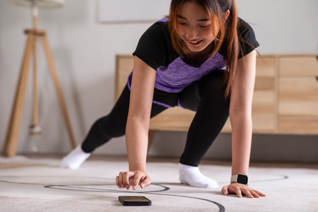 Asian woman in sports wear doing workout at home with smart phone. home exercise conceptの写真素材