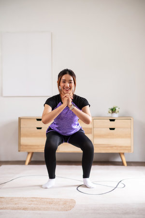 Asian women is doing forward lunge exercises at home.の写真素材