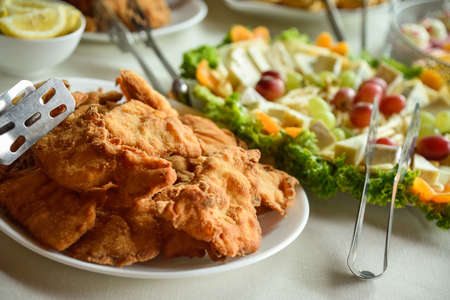 Fried pork and chicken cutlets in a wedding banquet with cheese and salad in the backgroundの写真素材