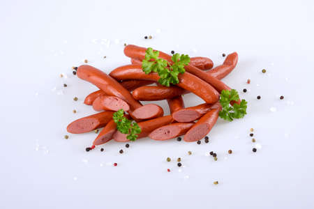 Smoked pork sausages, grill sausages, isolated on white background with scattered pepper.の写真素材