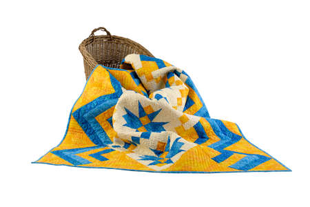 Patchwork yellow-blue quilt on a white background. Patchwork blanket. Handmade. Patchwork quilt on a...