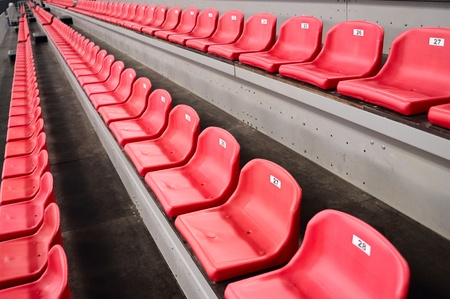 Rows of an empty red plastic seats on tribuneの写真素材