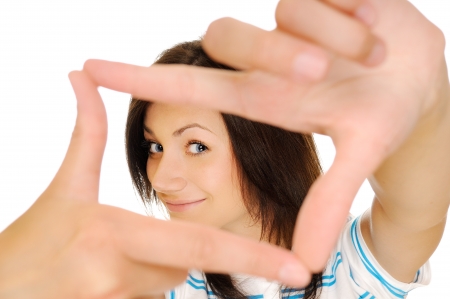 Portrait of beautiful young girl making frame gesture on white backgroundの写真素材