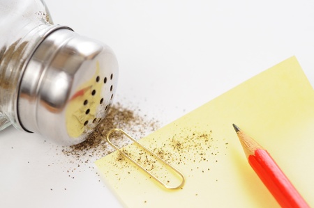 Pepper shaker, pencil and sheet of paper on the white tableの写真素材