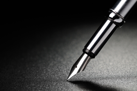 Old fountain pen on a black textured backgroundの写真素材