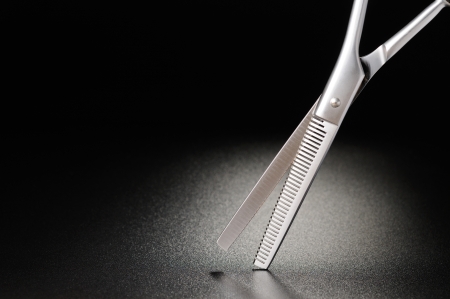 Professional hairdressing scissors on a black matt backgroundの写真素材