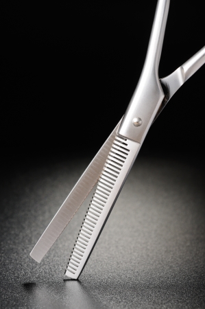 Professional hairdressing scissors on a black matt backgroundの写真素材