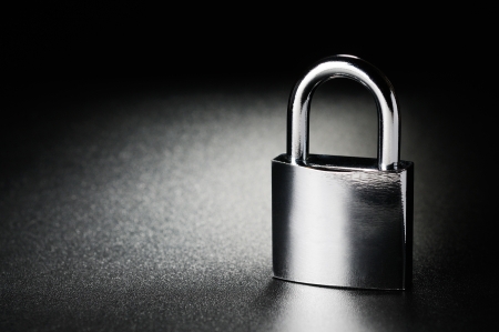 Steel padlock on the black textured background