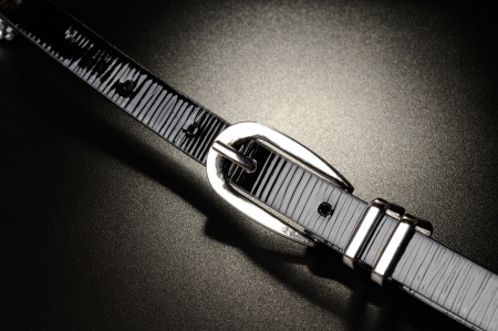 Black leather belt on a black surfaceの写真素材