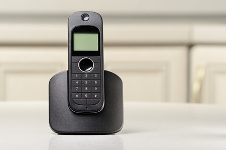 Black cordless phone standing on a tableの写真素材