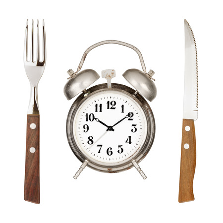 Eating time concept  Alarm clock, knife and fork isolated on white backroundの写真素材