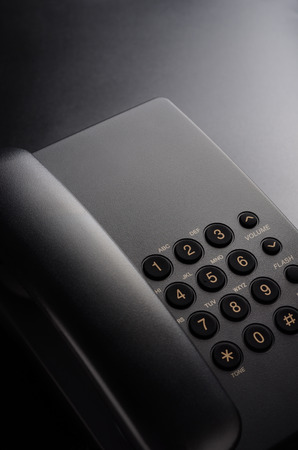 Black wired phone on a black backgroundの写真素材