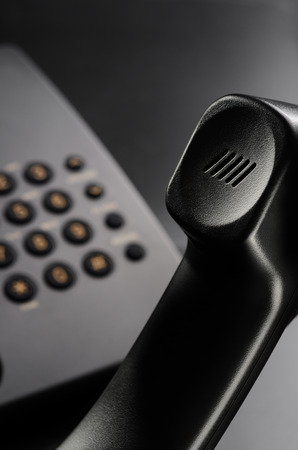 Black wired phone on a black backgroundの写真素材