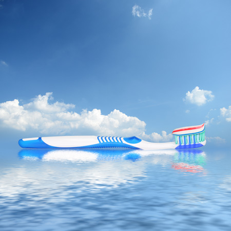 Toothbrush with toothpaste reflecting in water against sky backgroundの写真素材