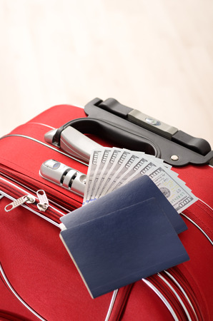 Red Suitcase, passports and money on a wooden floor in empty roomの写真素材