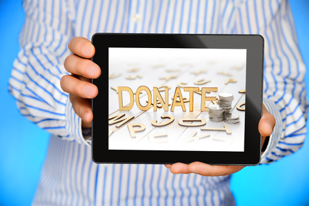 Businessman showing black tablet computer with donate word on the screen.の写真素材