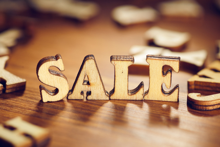 Sale word made from letters on wood plank table. Macro shotの写真素材