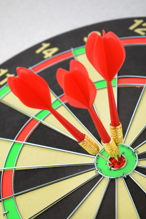 Darts board with dart arrow close up - three in bull's eye
