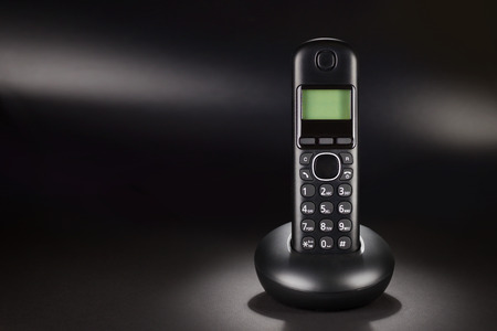 Cordless phone on black background with empty space for your textの写真素材