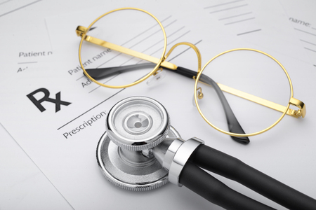 Prescription or Rx form with medical stethoscope and glasses on the doctors deskの写真素材