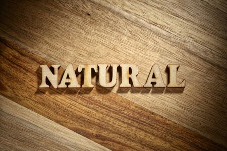 Word natural made with wooden letters on the wood board. Healthy products conceptの写真素材