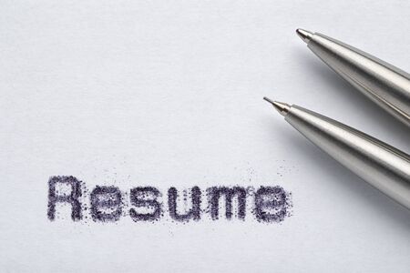 Metal ballpoint pen and automatic pencil on white paper with Resume word printed by typewriter