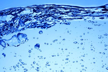 Bubbles of air under blue water and wave or splash. Background or texture
