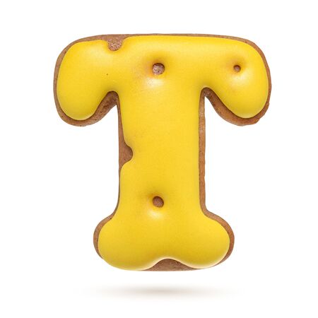 Capital letter T yellow homemade gingerbread biscuit isolated on white background.の写真素材