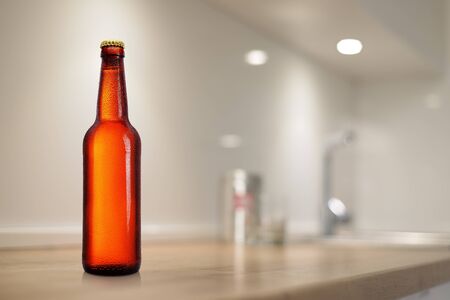 Brown beer bottle on kitchen table. Mock-up design presentation. No label, water drops.の写真素材