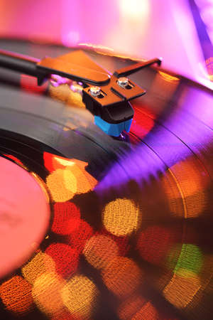 Vinyl player tonearm with LP record and blured or defocused lights. Party disco conceptの写真素材