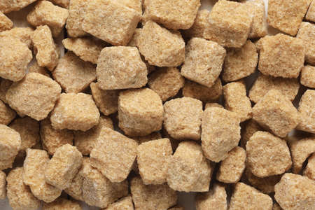Brown rough cut sugar cubes texture background macro shot.