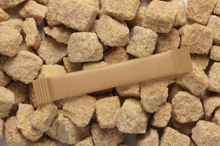 Blank brown paper sachet stick pack on rough cut sugar cubes. 3D rendering and photo.