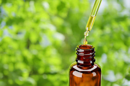 Amber bottle with dropper green nature background.. 3d rendering illustration.の写真素材