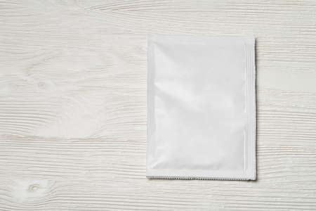 White blank paper sachet packet on wood table. Mock-up template for design.の写真素材