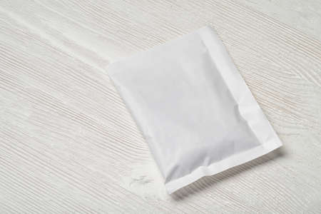 White blank paper sachet packet on wood table. Mock-up template for design.の写真素材