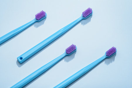 Modern blue toothbrushes, green and yellow on a blue background. Flat lay style, top view.の写真素材