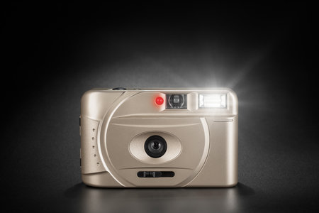 Classic point-and-shoot film camera with a glowing flash for capturing moments on black background.