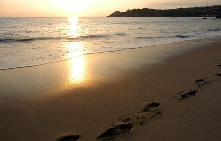 Footprints in sand on the beach during the sunset, Puerto Escondido, Mexicoの写真素材