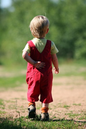 Little girl in red trousers  from backの写真素材