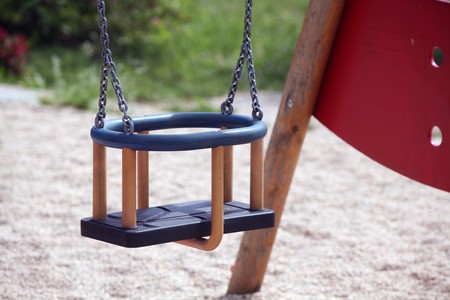 Detail of empty swing on playgroundの写真素材