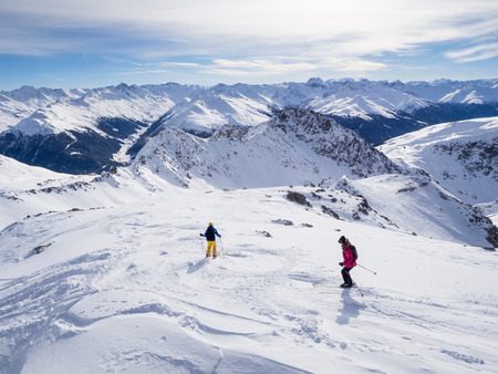 A couple of skiers skiing downhil course in the Parsenn mountains, Davos, Switzerland, 2015のeditorial素材