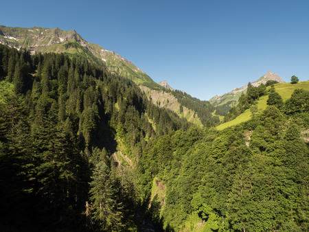 A view of Alpine mountains surrounding the village Schroecken in Bregenzerwald, region Vorarlberg, Austriaの写真素材